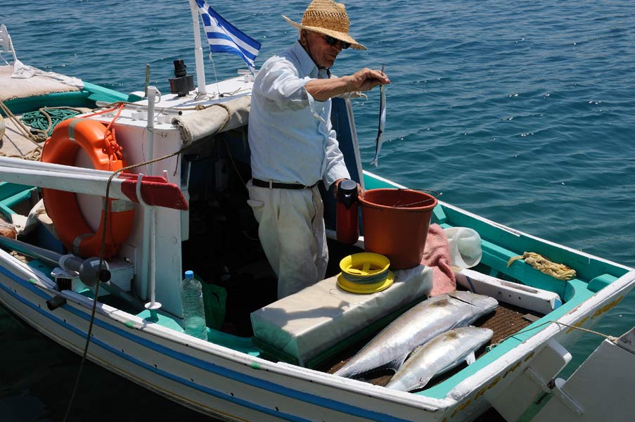 Ein Fischer in seinem Boot in dem Dorf Lagada auf der Insel Chios – Früher gab es viele Fischer in Griechenland, aber heutzutage werden immer mehr Fischerboote aufgegeben oder verkauft.